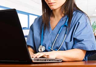 Nurse Looking Up Something on Laptop